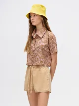 Camisa crop de viscosa con estampado abstracto en tonos marrones y rosados, cuello solapa y cierre frontal con botones.
