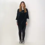 Poncho de acrílico color azul con flecos en el ruedo.