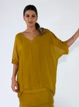 Blusa de viscosa color mostaza, con escote en V, mangas cortas holgadas y diseño amplio.