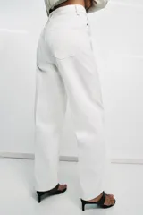 Jeans blancos de tiro alto con diseño wide leg, detalle de nervio delantero y pespuntes marcados a contraste. Presenta cierre frontal con cremallera y botón, y cinco bolsillos.
