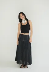 Falda larga negra con diseño de caderín y tablas.