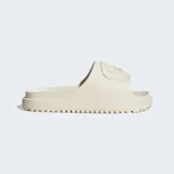 Ojotas Adidas modelo Campus 00s, confeccionadas en una sola pieza de espuma sintética color beige. Presentan un diseño minimalista con el logo Campus 00s grabado en la banda superior y suela con ranuras para mayor agarre.
