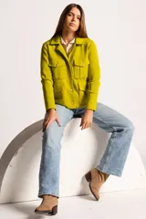 Chaqueta color verde lima de tejido en lana, con cuello clásico, cierre frontal con botones dorados y cuatro bolsillos con solapa en el frente.