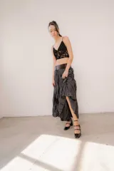 Pollera larga de tejido texturizado con efecto arrugado y acabado satinado, de color gris oscuro, con pretina ancha y silueta acampanada.