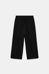 Pantalón negro de tiro medio, con cintura elástica ajustable con cordones. Incluye bolsillos laterales ocultos en la costura y bolsillos de plastrón en la espalda.