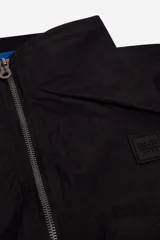 Campera negra de nylon, resistente y liviana, con cuello y cintura en rib, logo en grifa de goma y puños.