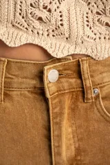 Jean de tiro alto con corte wide leg y acabado lavado en tono camel. Presenta diseño de cinco bolsillos, cierre frontal con botón y cremallera, y bajo con terminación al corte.