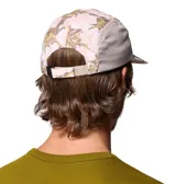 Gorro tipo gorra Columbia modelo Wingmark Cap, con paneles laterales de malla gris y diseño estampado camuflado en tonos rosados y blancos en el frente y la visera. Cuenta con logo bordado de la marca.