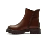 Bota corta estilo chelsea de cuero color marrón, con suela track dentada y detalle de tira con hebilla metálica en el tobillo.