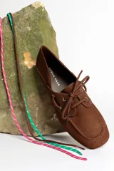 Mocasín de cuero marrón con cordones, diseño de puntera cuadrada y costuras visibles.