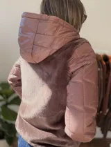Campera con cuerpo de piel sintética tipo teddy y mangas acolchadas. Presenta cierre frontal, capucha y diseño de corte recto.