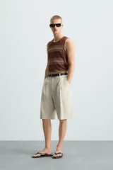 Camiseta sin mangas (manga sisa) de punto, color marrón con rayas horizontales en tono beige/tostado. Presenta cuello redondo con acabado en rib.