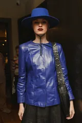 Campera de cuero ovino italiano color verde azulado, con cuello mao, cierre frontal con broches ocultos, bolsillos laterales y detalle de capitoneado en puños y bolsillos.