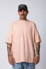 Remera blanca de corte oversize con cuello redondo y mangas cortas. Presenta un pequeño estampado tipográfico en la parte inferior frontal y un diseño gráfico de mayor tamaño en la espalda.