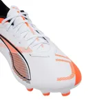 Championes de fútbol Puma Ultra 5 Play FG/AG, color blanco con detalles en naranja y negro. Diseño aerodinámico con suela de tapones para césped natural y artificial.