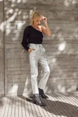 Pantalón babucha plateado de cuero de oveja italiano impermeabilizado, con cintura elastizada, bolsillos laterales y tobillo recto. Incluye cintas del mismo cuero para fruncir el puño del tobillo.