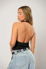 Top de cuello volcado, confeccionado en tela de punto suave, con diseño sin mangas y ajuste al cuerpo.