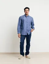 Camisa celeste con microestampado blanco, de corte clásico, manga larga y cuello abotonado. Tiene un bolsillo en el pecho.