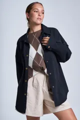 Sobrecamisa color beige de gabardina con cuello camisero, cierre frontal con botones a presión, dos bolsillos de parche en el pecho y corte holgado.