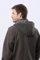Campera repelente al agua y cortaviento de color negro, con capucha desmontable, cierre frontal y parche circular en el pecho.