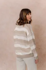 Buzo de tejido liviano con diseño de rayas horizontales en tonos amarillo manteca y blanco, cuello redondo y mangas largas con puños tejidos.