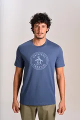 Remera de cuello redondo y manga corta, color azul, con estampado circular en el pecho que incluye el logo de la marca Original Penguin.