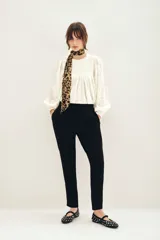 Pantalón negro estilo babucha de corte relajado, con cintura elástica ajustable mediante cordón y bolsillos diagonales en el frente.