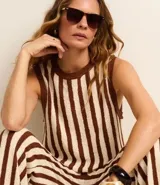 Pantalón de punto color crema con rayas verticales marrones, de corte recto y cintura alta con elástico.