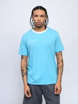 Remera de corte clásico color blanco, con cuello redondo en color rosado y logo de la marca bordado en el pecho en el mismo tono.