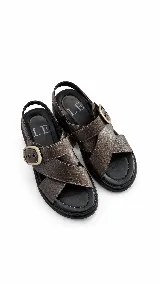 Sandalias planas de cuero marrón con textura reptil, tiras cruzadas en el empeine, hebilla metálica lateral y tira trasera de sujeción. Plantilla y suela negra.