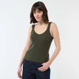 Musculosa de tejido de canalé en color verde oliva, con escote redondo y terminaciones con borde ondulado.