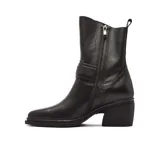 Bota de caña media confeccionada en cuero color bordó, con taco cuadrado bajo y detalle de tira con hebilla metálica en el tobillo.