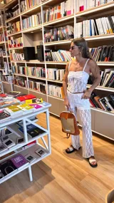 Top blanco de encaje con breteles finos y cierre frontal con botones.