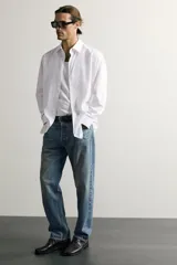 Jeans regular fit confeccionados en denim de algodón celeste con efecto lavado, de cinco bolsillos y cierre frontal con cremallera y botón.