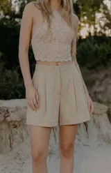 Short de vestir color beige, de tiro alto, con pinzas delanteras y silueta amplia.
