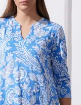 Blusa amarilla estampada con motivos florales en blanco, escote en V y mangas tres cuartos.