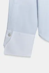 Camisa de algodón con cuello solapa y puños en color blanco a contraste. Presenta cierre frontal con alamares negros y bajo asimétrico redondeado.