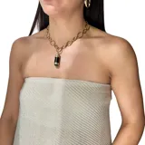 Collar de cadena de eslabones ovalados en acero dorado, con un dije colgante cilíndrico de onix negro y ágata verde, decorado con detalles de strass.