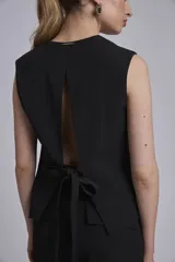 Chaleco negro con escote en V y cierre frontal con botones.