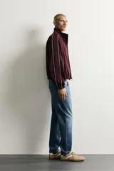 Jeans de corte slim cropped confeccionados en denim de algodón rígido con efecto lavado. Presentan tiro medio, cierre frontal con cremallera y botón, y diseño clásico de cinco bolsillos.