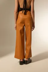 Pantalon de tiro alto confeccionado en eco-cuero, con diseño de pierna ancha y corte recto.
