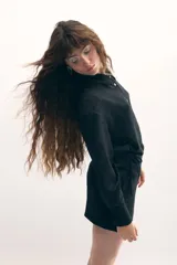 Vestido camisero negro con sobrefalda integrada, botones de nácar y estampado con leve rugosidad.