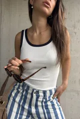 Musculosa de tejido ribb color blanco, con cuello redondo y ribetes en contraste de color azul marino.