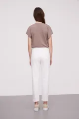 Pantalon de jean blanco, de corte skinny y tiro alto, con cierre frontal y bolsillos laterales.