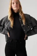 Jean de tiro alto con corte acampanado (flare), en color negro. Presenta un diseño clásico de cinco bolsillos y cierre frontal con botón y cremallera.