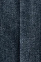 Jean tobillero de denim azul con leve elasticidad, tiro alto y perneras amplias tipo wide leg. Presenta bolsillos delanteros tipo parche con solapa y botones metálicos, además de pliegues marcados al frente y en la espalda.