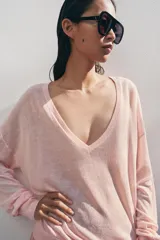Jersey de punto fino negro con escote en V profundo y manga larga con puños ajustados.