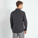 Camisa negra de corte recto, manga larga y cuello clásico.