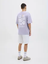 Camiseta lila de manga corta con estampado en la espalda de hojas y círculos en tonos blanco y naranja.