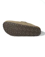 Zuecos de gamuza color beige con diseño de punta cerrada y ajuste lateral mediante tira con hebilla metálica grabada. Presentan una plantilla anatómica de corcho y látex, con suela de goma antideslizante.